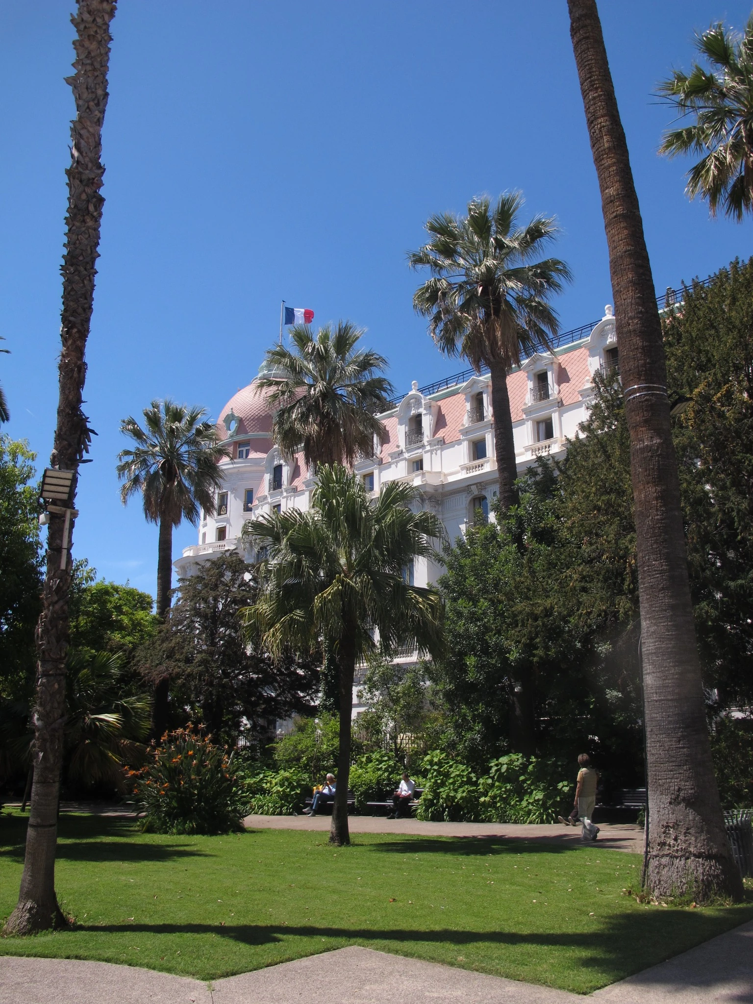 Belle Époque hotel seen through palm trees